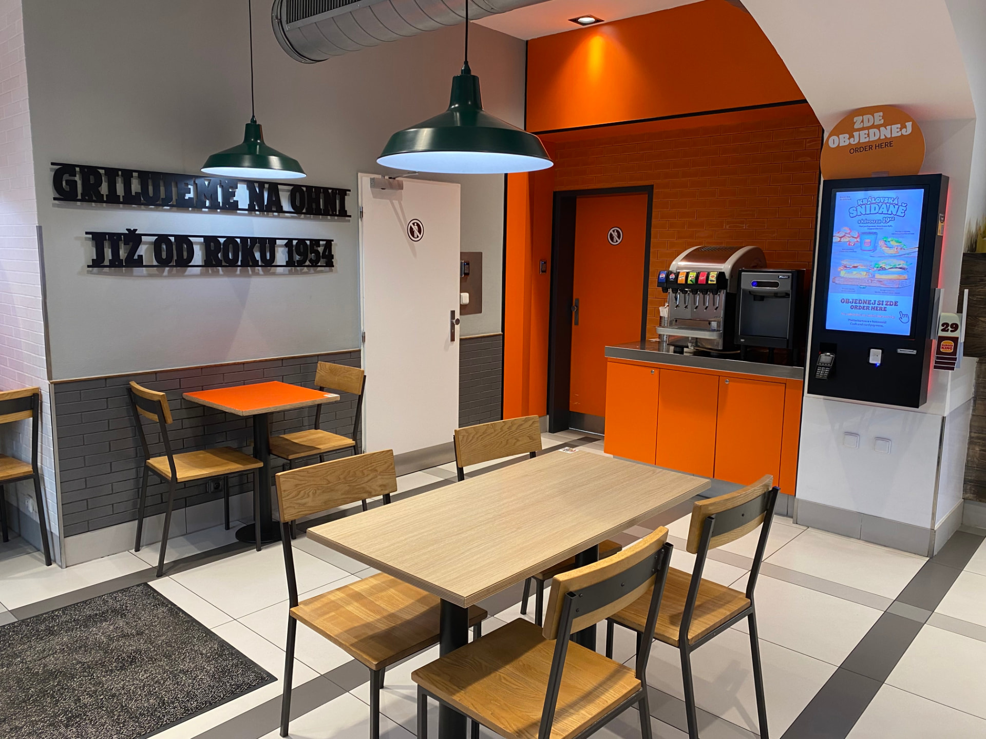 Interiér restaurace Burger King Masarykovo nádraží s kiosky pro objednávku